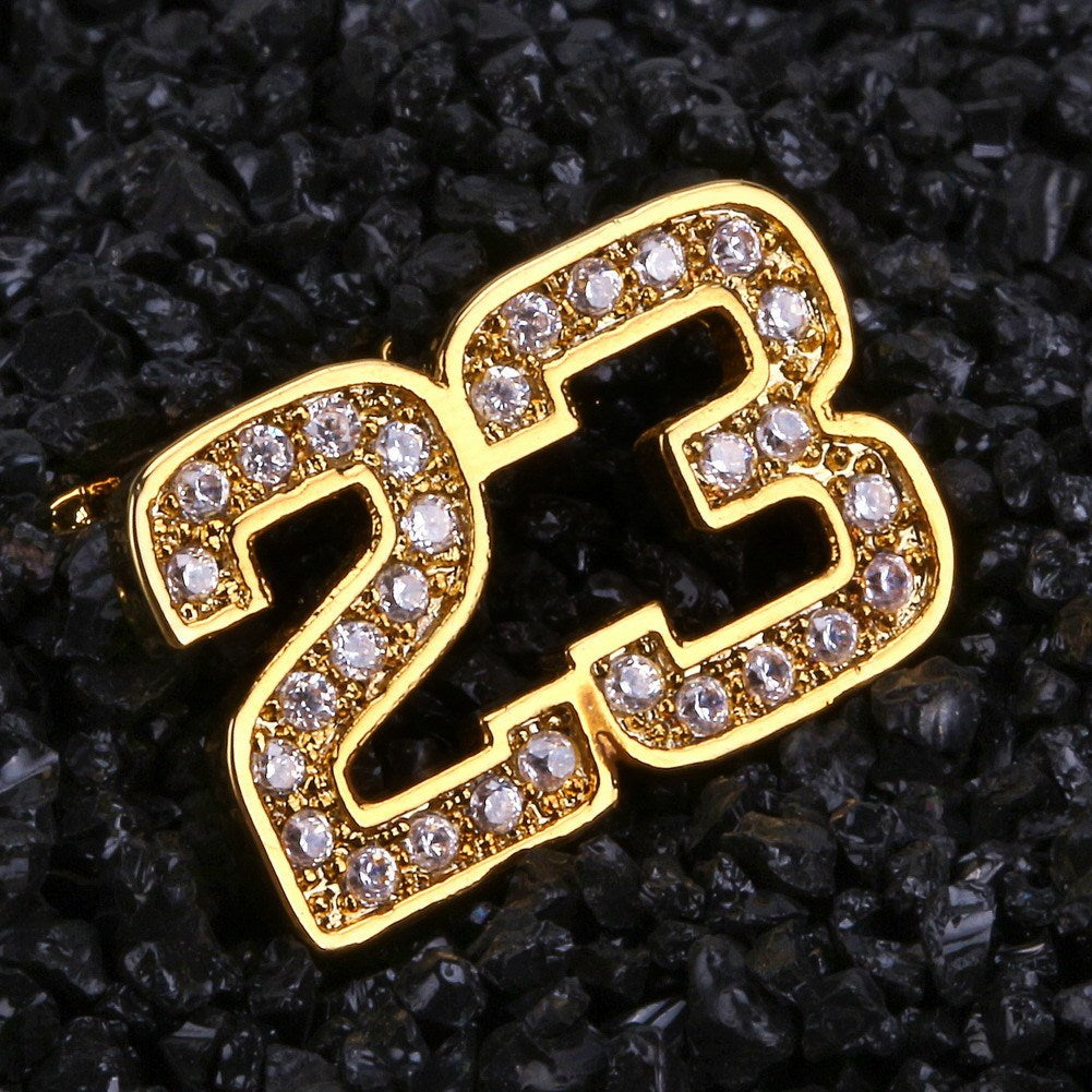 DatNewDrip gold 23 two tooth grillz set encrusted with clear crystals shown on black textured background