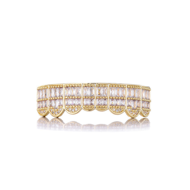 Gold iced out baguette grillz with rows of baguette and round stones on white reflective background
