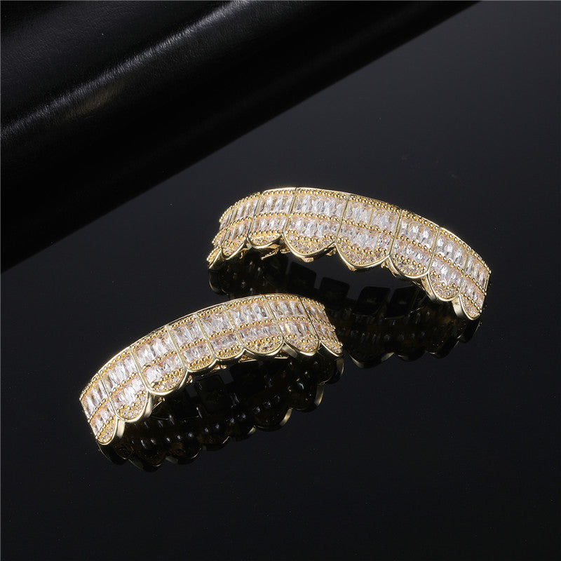 Gold scalloped iced out baguette grillz with clear cubic zirconia stones on black reflective background