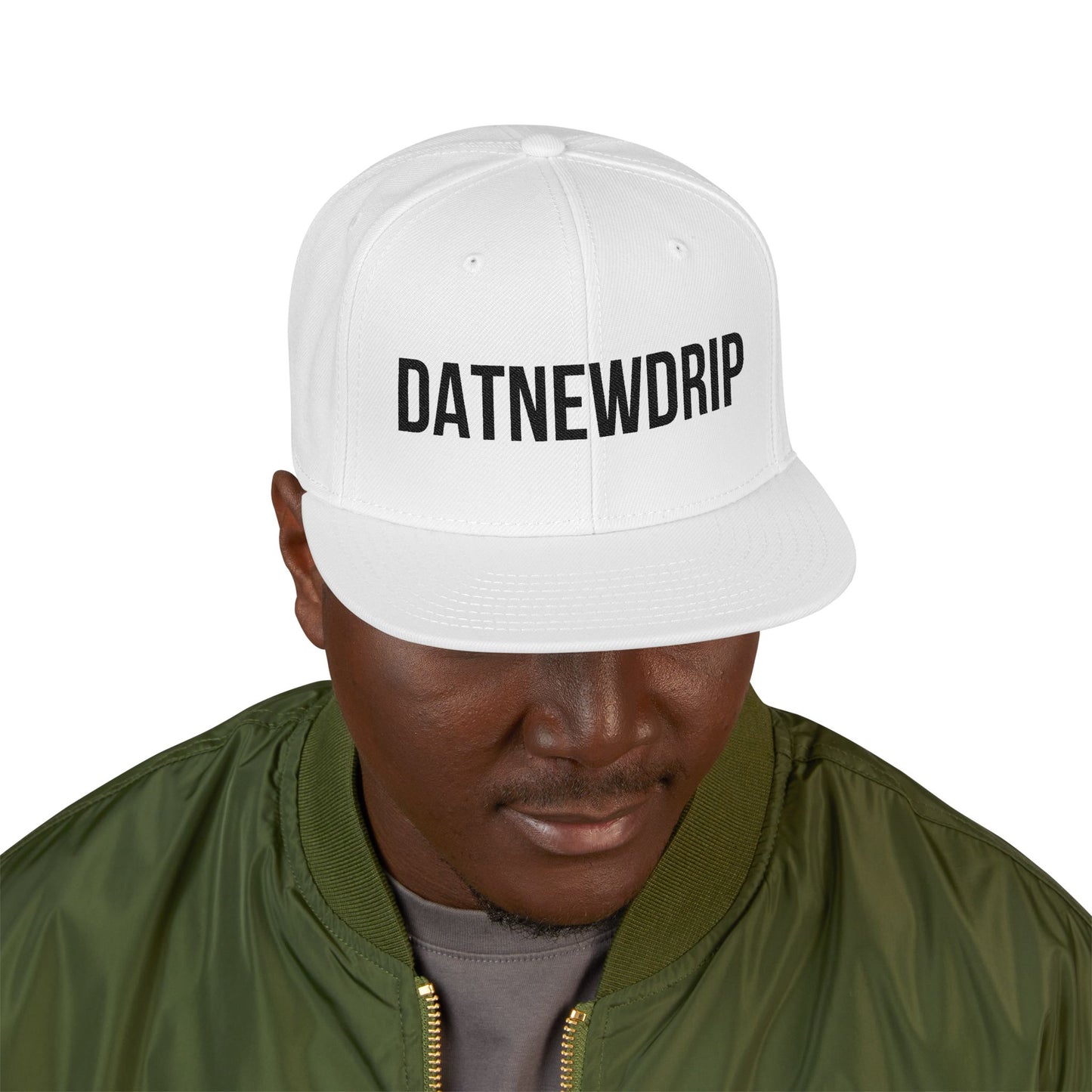 DatNewDrip white snapback hip-hop style hat with black logo worn by a man in green jacket