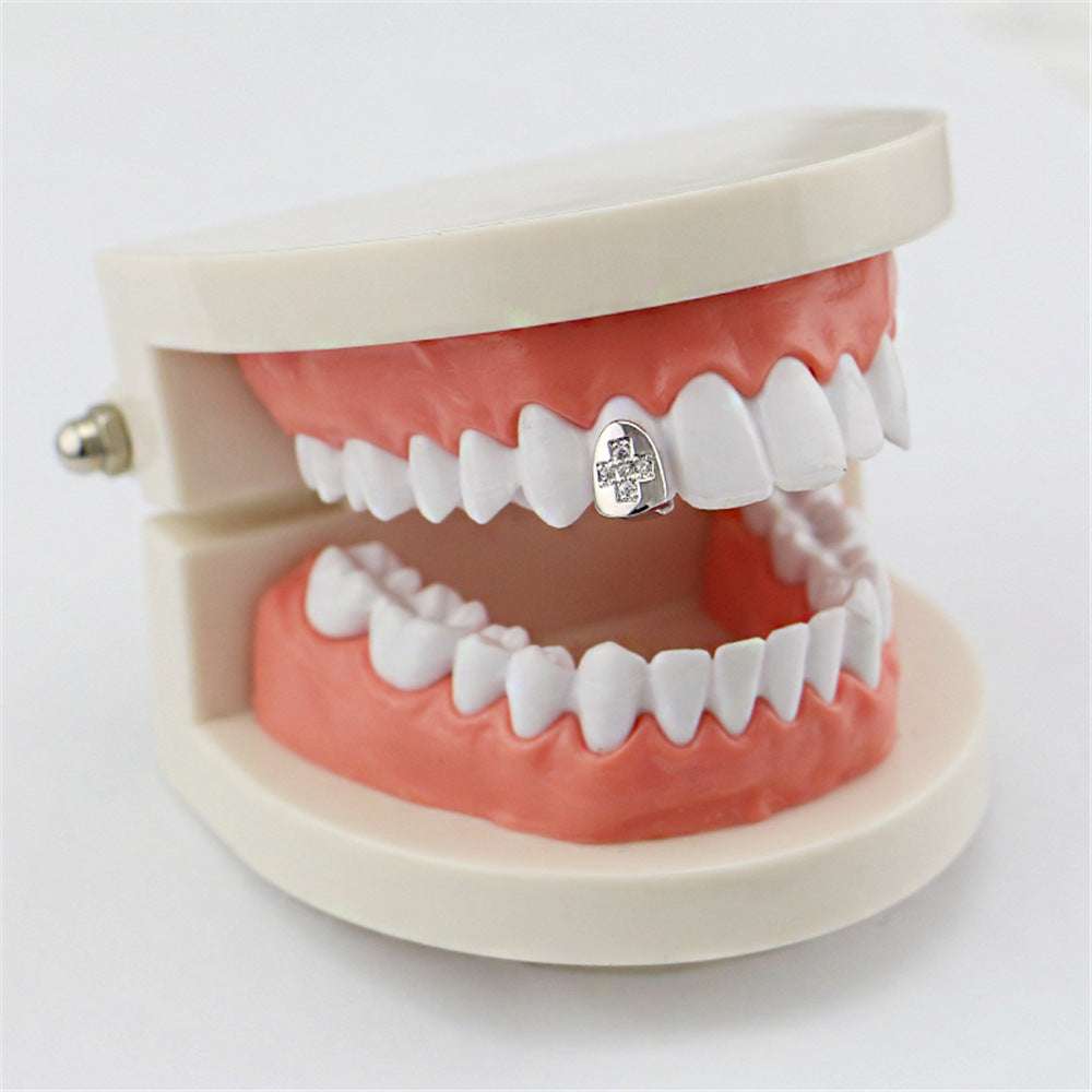 Dental model displaying a diamond cross hip hop tooth grill on a single upper front tooth with silver finish