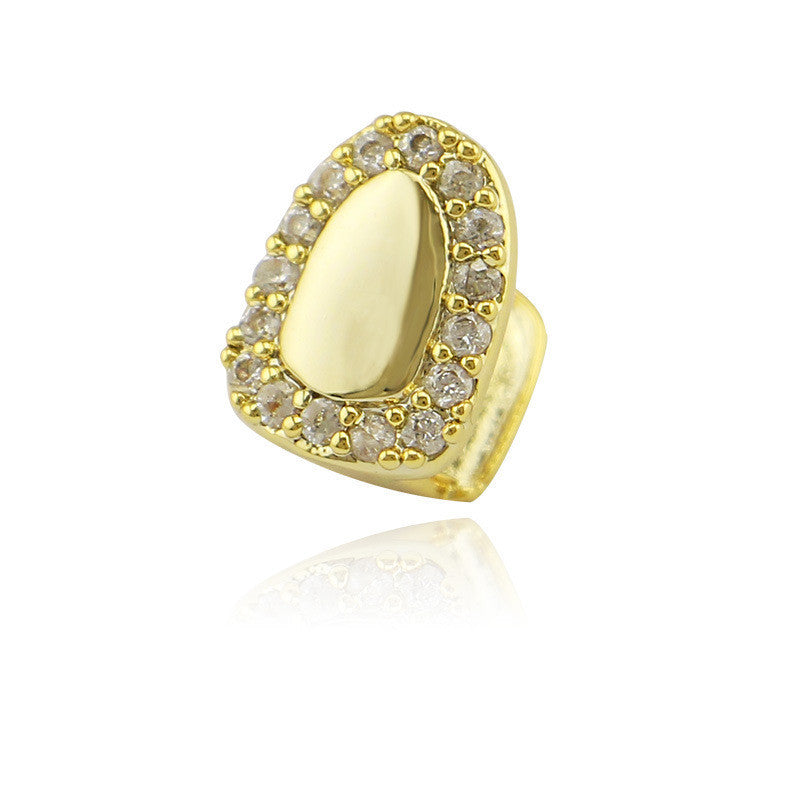 Gold iced out single tooth grillz with clear crystal halo and polished gold center on white background