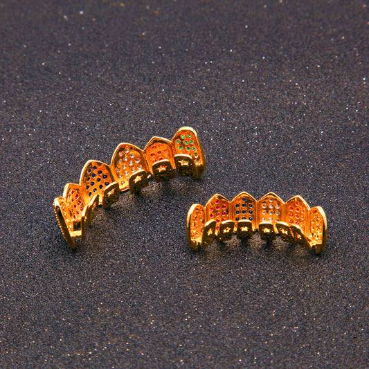 Gold plated tooth caps set with multicolored gem grillz inlaid on top and bottom on black glitter background