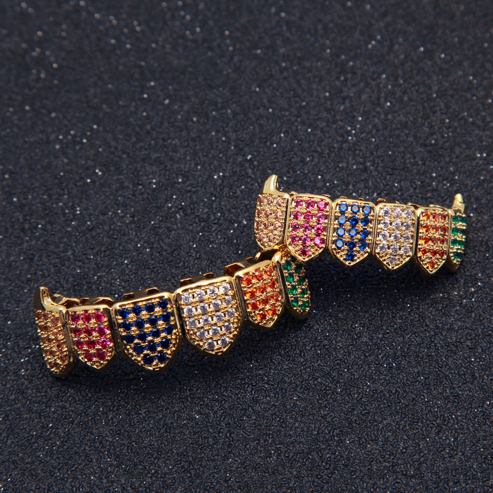 Gold dental grill set with pave multicolored gems on black background showcasing multicolored gem grillz for streetwear style