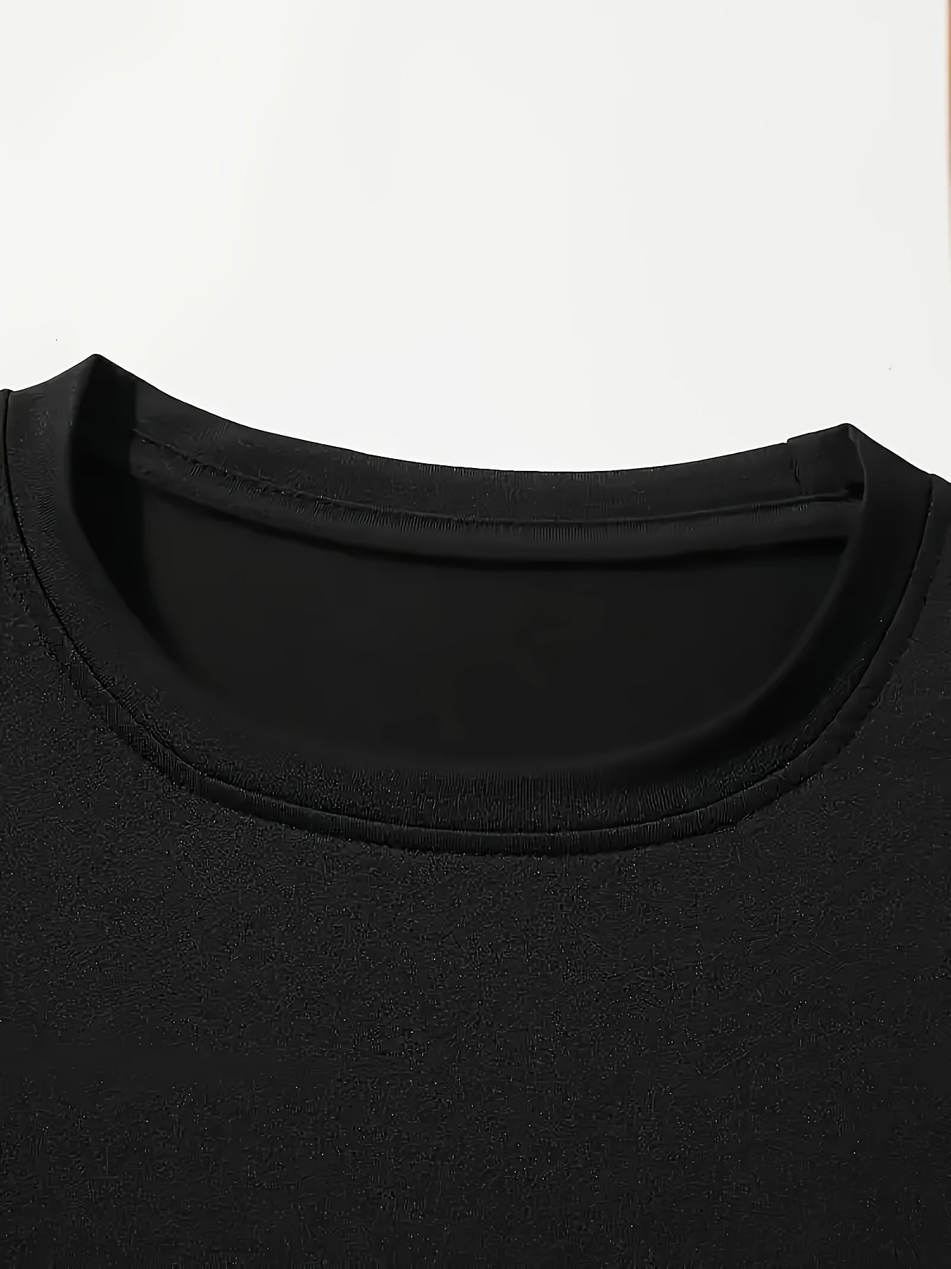 Close-up of a black Graphic Streetwear T-Shirt showcasing a crew neckline and smooth fabric texture