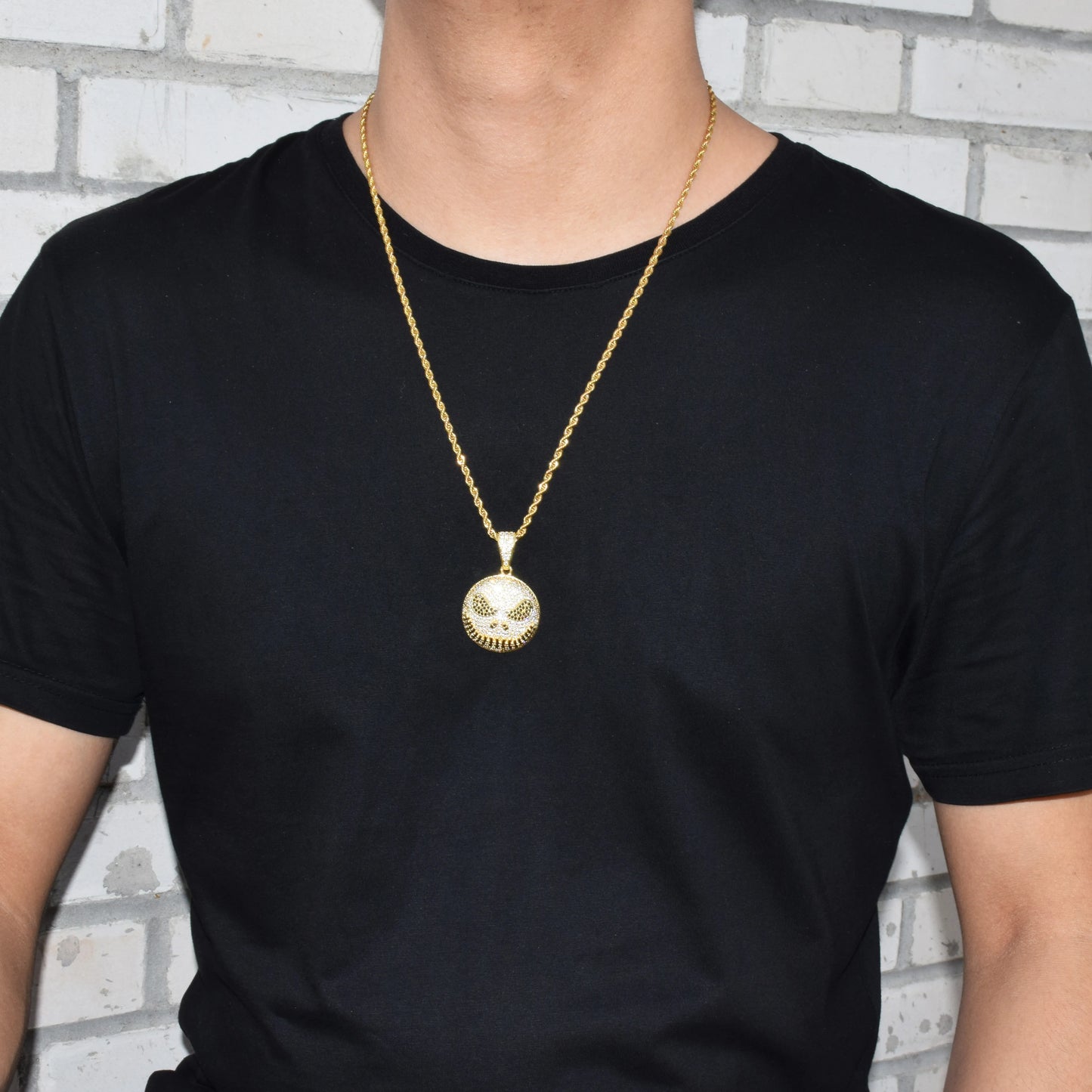Iced out Jack Skeleton smiling pendant necklace displayed on a model wearing a black t-shirt