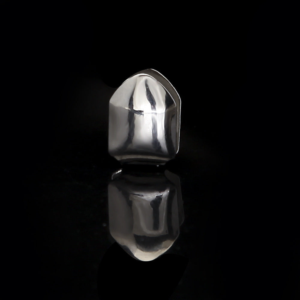 Polished silver single tooth grillz displayed on black reflective surface showing mirror reflection