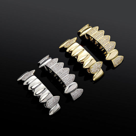 Gold and silver iced out fang grillz with pave cubic zirconia crystals displayed on black background