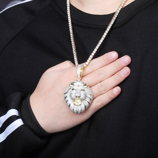 DatNewDrip iced out lion head pendant on gold chain worn over black shirt with hand on chest