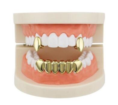 DatNewDrip gold vampire grillz for teeth on dental model showing upper fang caps and full lower set