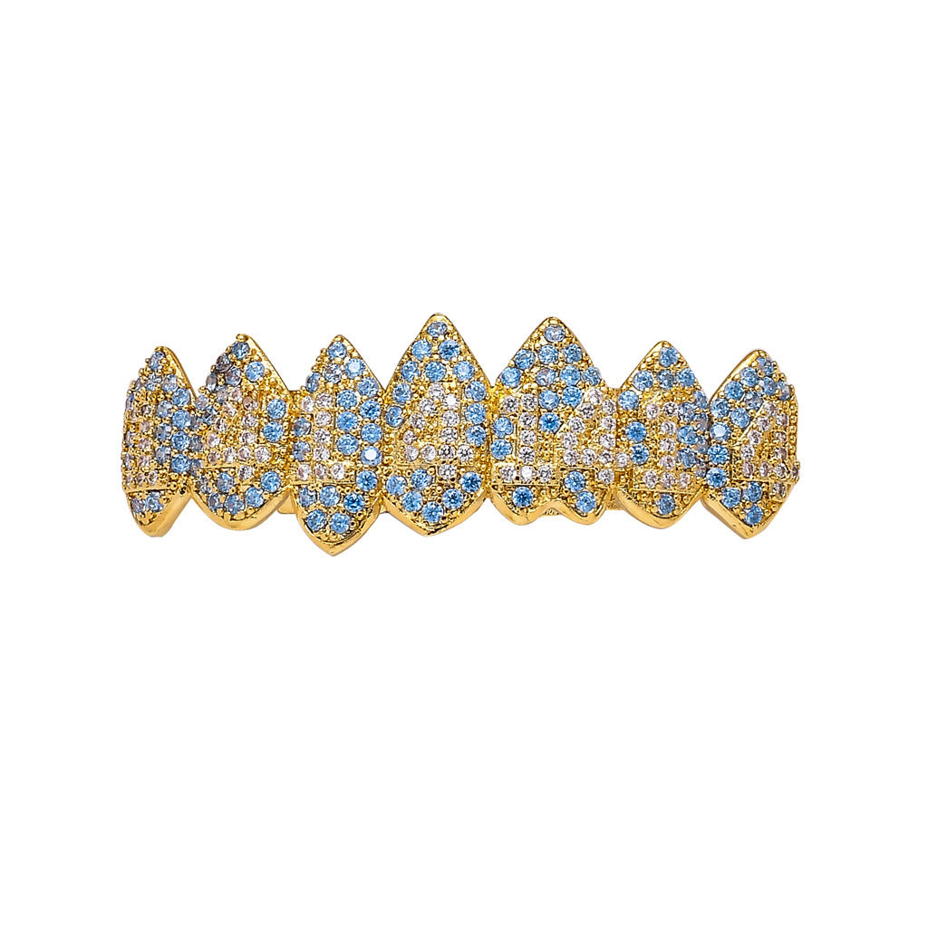 DatNewDrip gold iced out monster fang grillz with blue and clear stones close up on white background