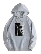 Gray hoodie with a graphic design on a wooden surface with flowers.