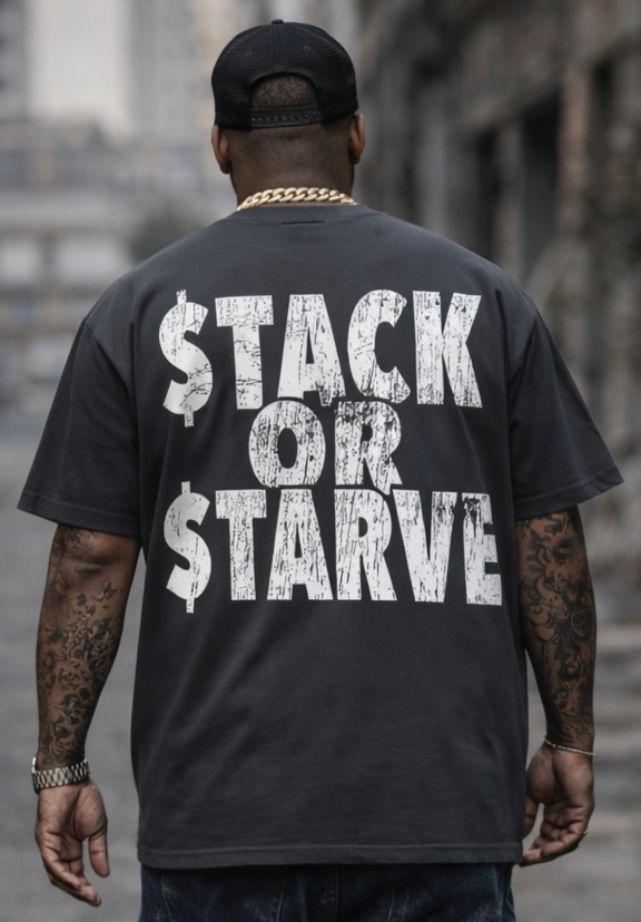 Person wearing a black t-shirt with 'STACK OR STARVE' text, walking on a street.