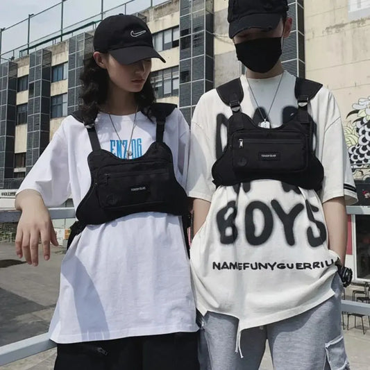 Two people wearing black waist bags with visible branding in an urban setting.