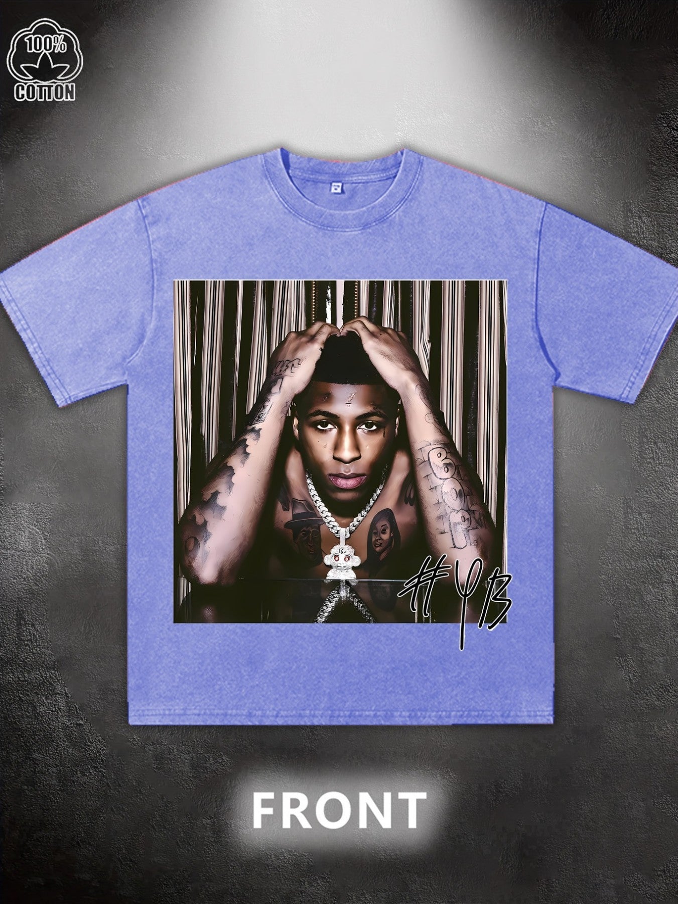 Blue t-shirt with a graphic of a person with tattoos and a necklace on a dark background.