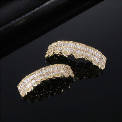 Gold scalloped iced out baguette grillz with clear cubic zirconia stones on black reflective background