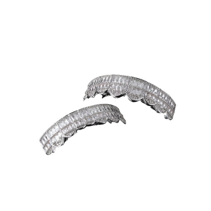 Silver two piece iced out baguette grillz with scalloped design and square baguette stones on top and bottom