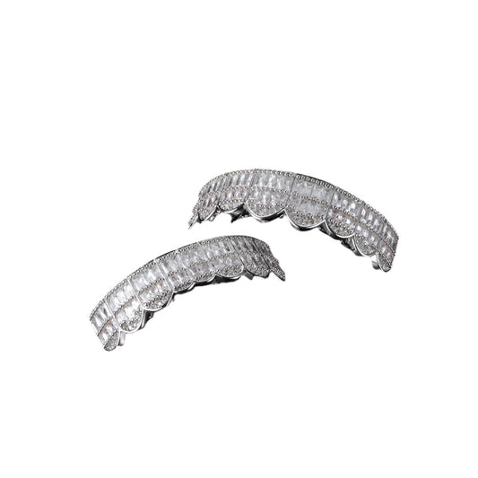 Silver two piece iced out baguette grillz with scalloped design and square baguette stones on top and bottom