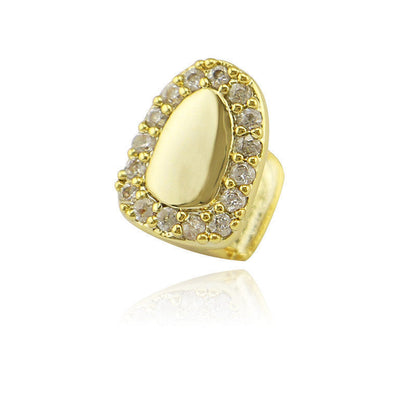 Gold iced out single tooth grillz with clear crystal halo and polished gold center on white background