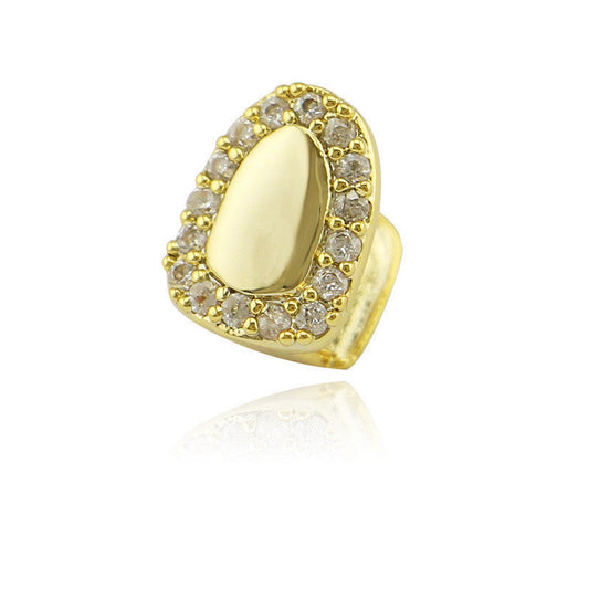 Gold iced out single tooth grillz with clear crystal halo and polished gold center on white background