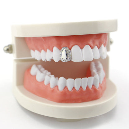 Dental model with white teeth showcasing iced out single tooth grillz on upper front tooth