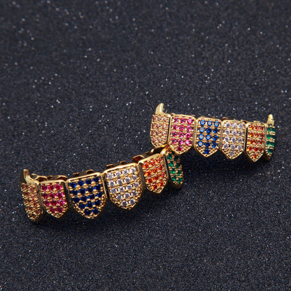 Gold dental grill set with pave multicolored gems on black background showcasing multicolored gem grillz for streetwear style