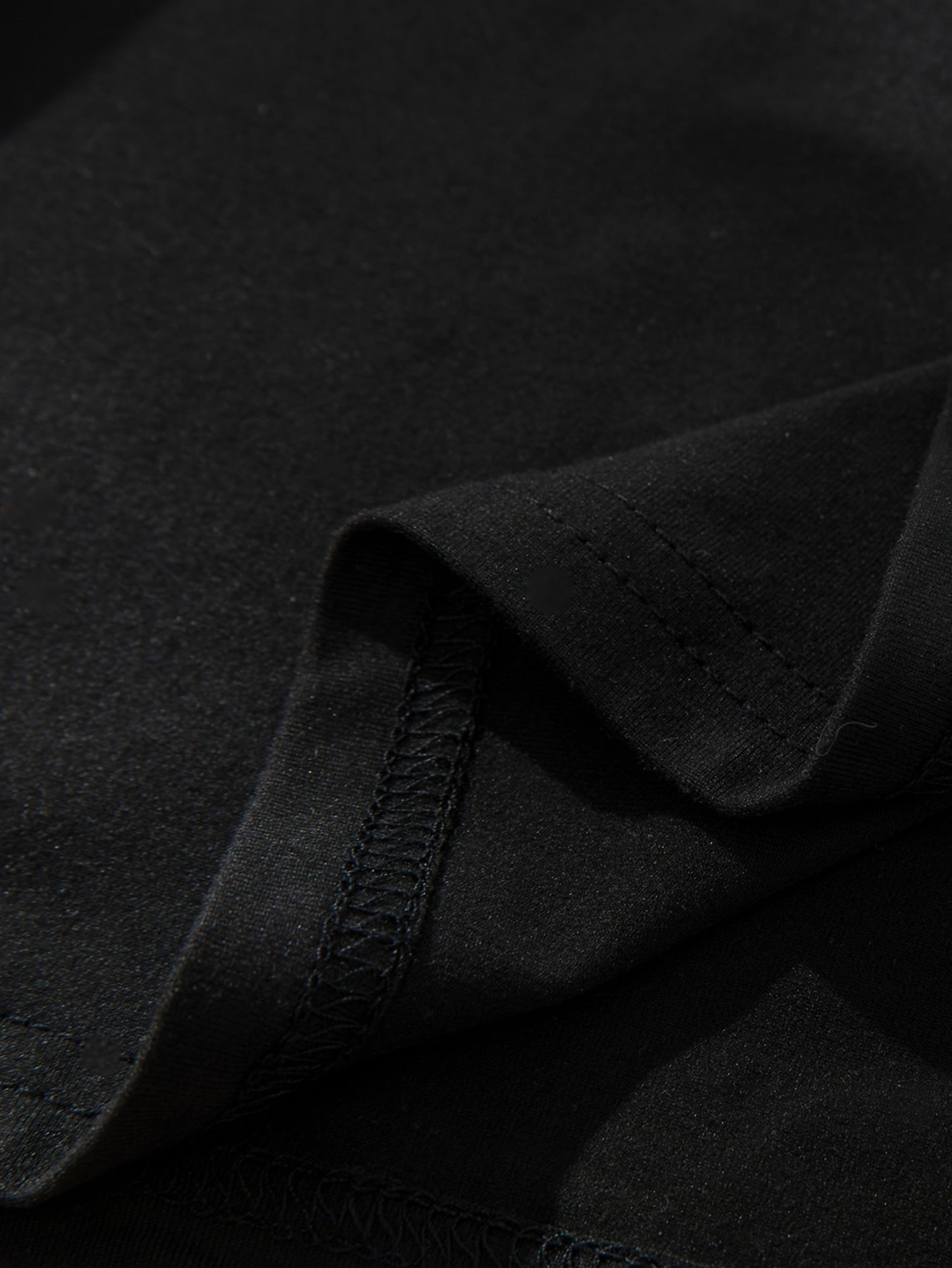 Close-up of a black graphic streetwear t-shirt showcasing premium fabric texture and stitching details