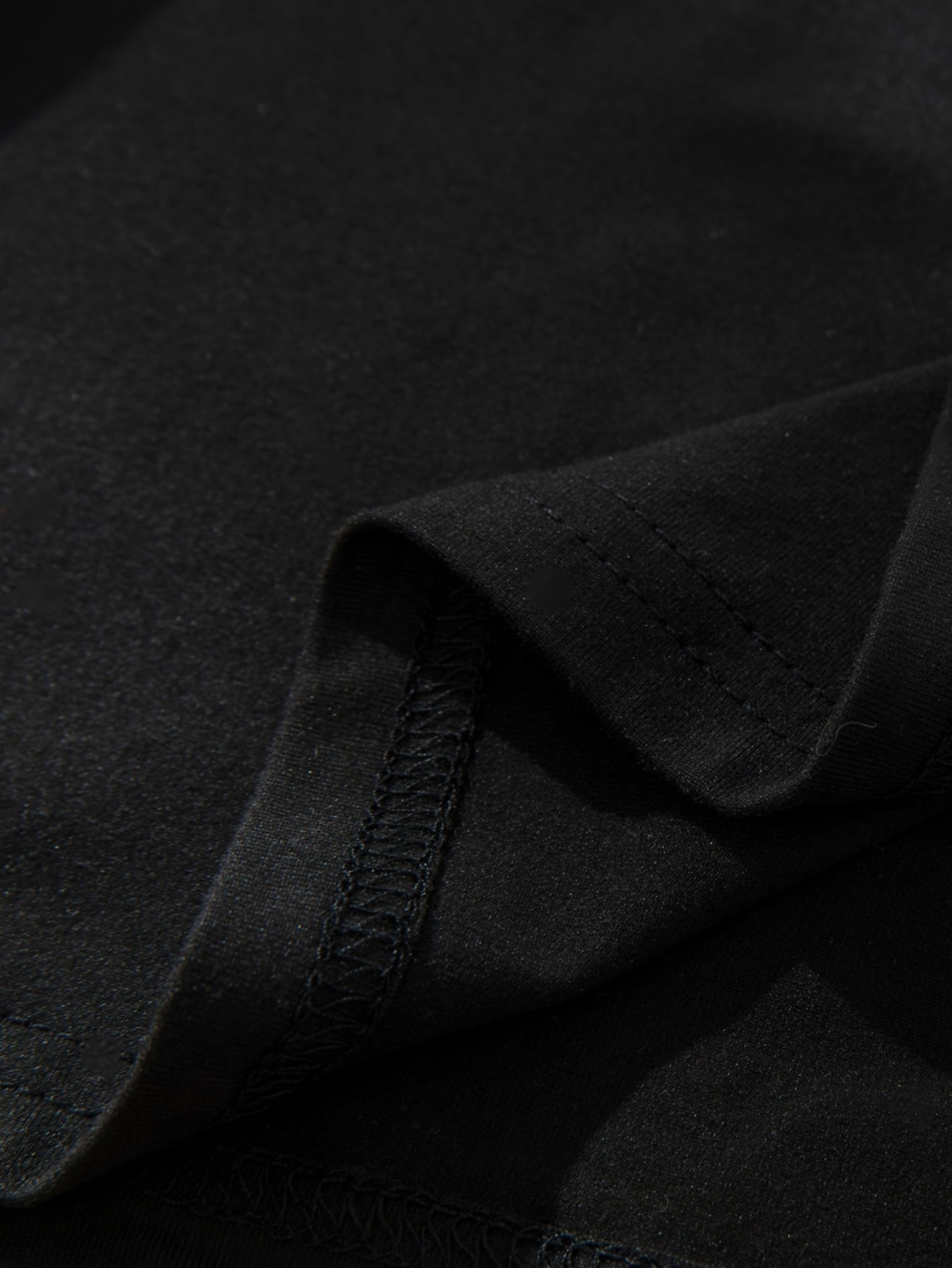 Close-up of a black graphic streetwear t-shirt showcasing premium fabric texture and stitching details