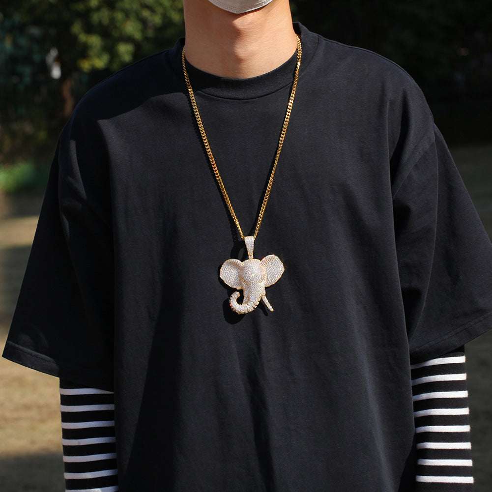 DatNewDrip iced out elephant pendant on a gold chain worn with a black shirt and striped sleeves