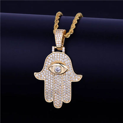 Iced out hamsa hand pendant necklace in gold with sparkling stones and eye design