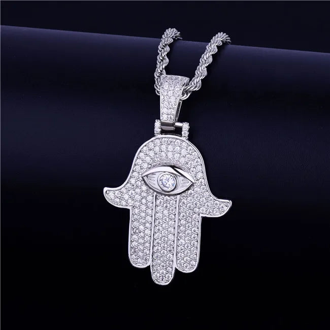 Iced out hamsa hand pendant necklace with intricate diamond detailing and eye motif