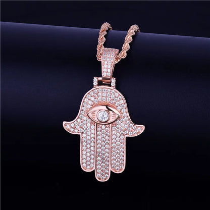 Iced out hamsa hand pendant necklace in rose gold with intricate eye design and sparkling embellishments