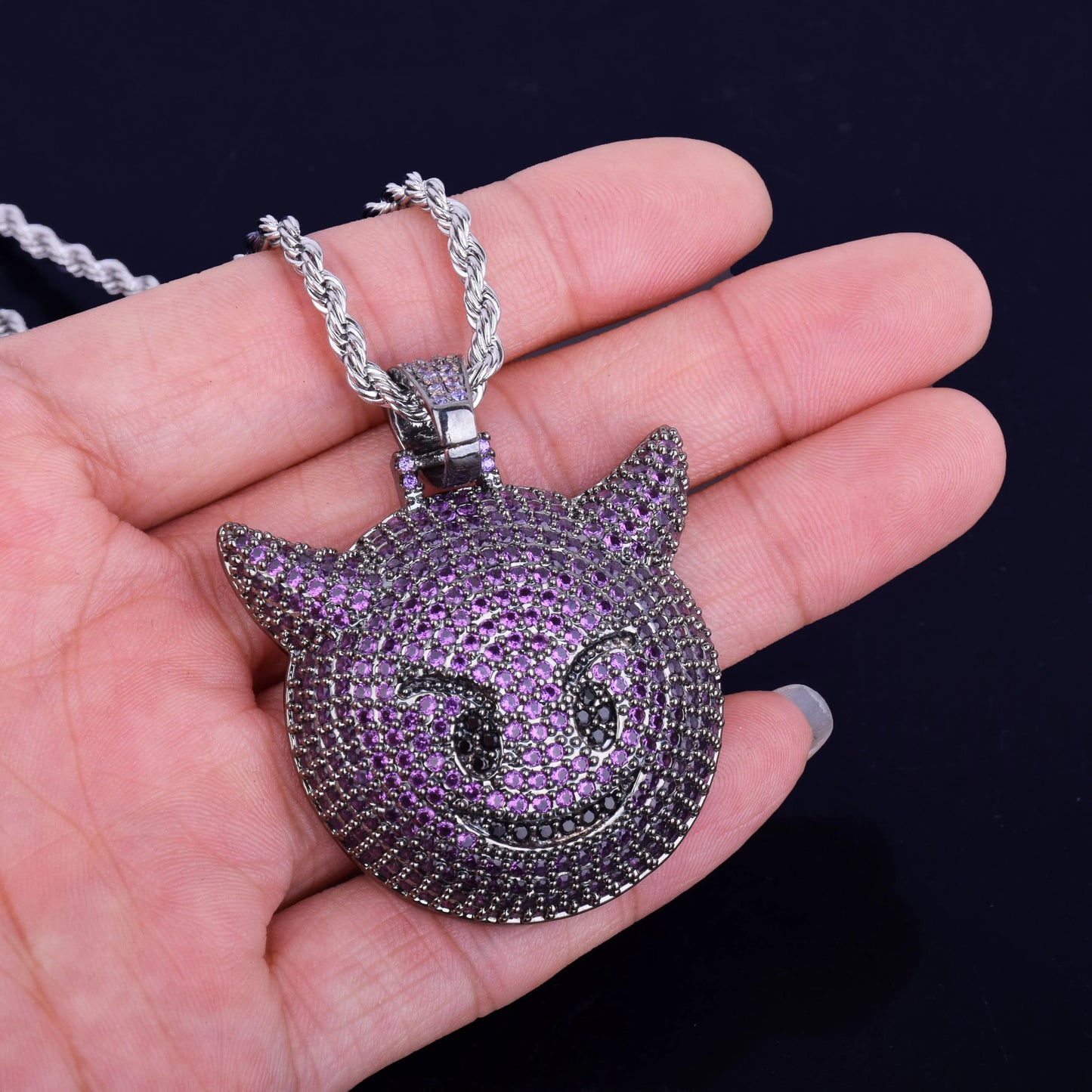 Iced Out purple demon pendant necklace with intricate purple and silver detailing held in hand
