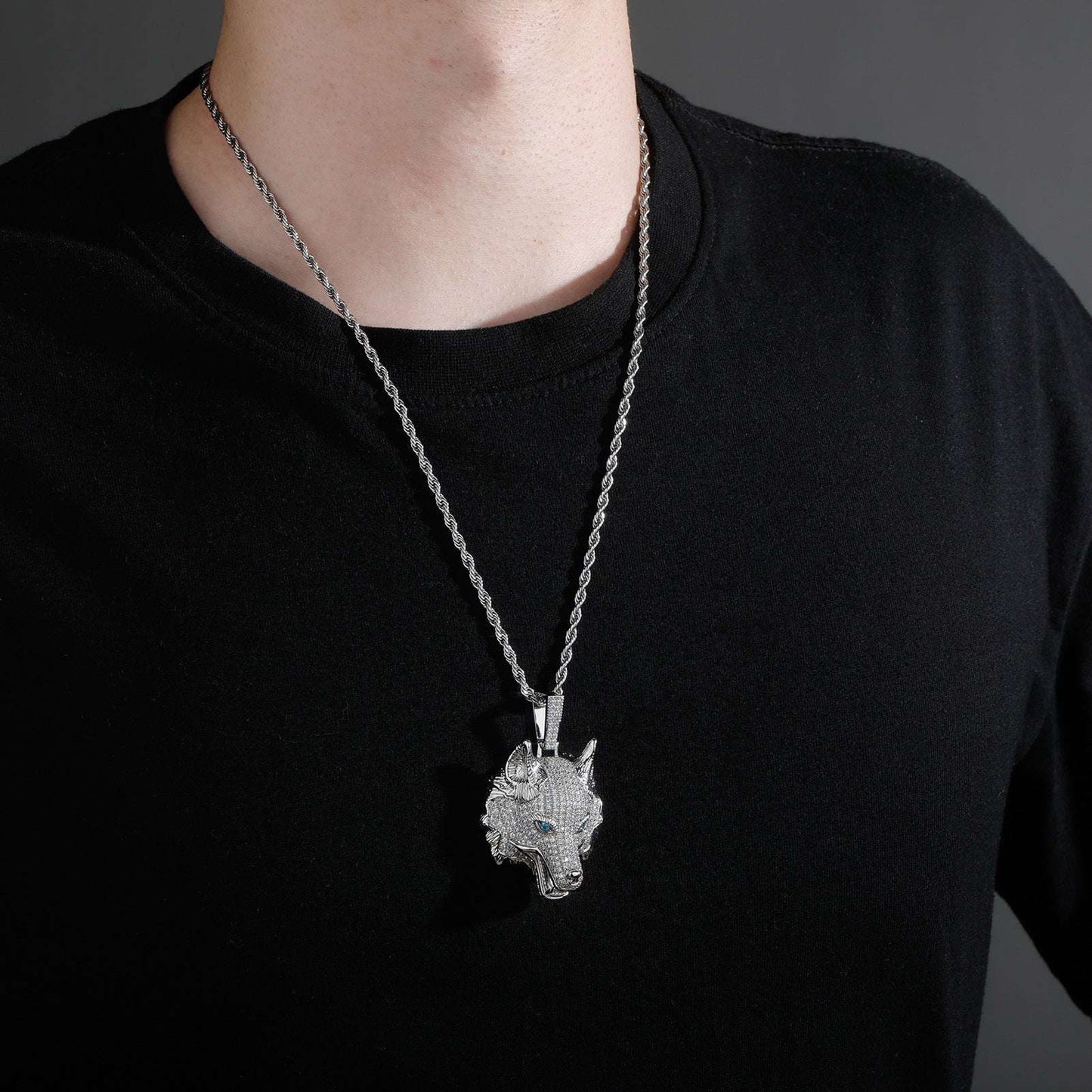 Iced out wolf pendant necklace by DatNewDrip worn on a silver chain with blue eyes