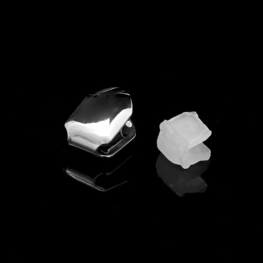 Polished silver single tooth grillz with clear dental molding and reflective black background