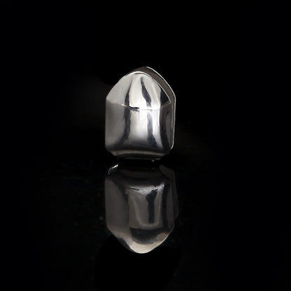 Polished silver single tooth grillz displayed on black reflective surface showing mirror reflection