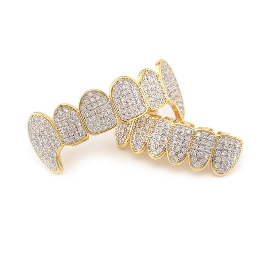 DatNewDrip gold plated iced out vampire fang grillz top and bottom with pave clear stones on white background