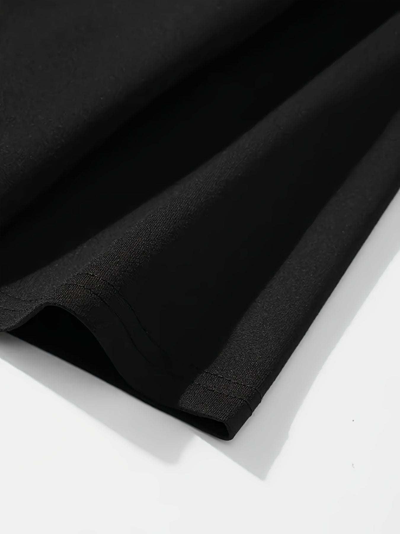 Close-up of the fabric texture of the Roots One Love t-shirt by DatNewDrip in black