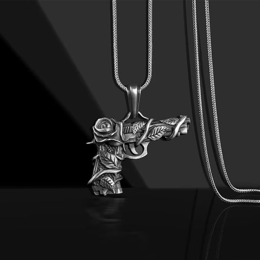 DatNewDrip silver men's gun and rose pendant necklace with detailed engraved rose vines on black background