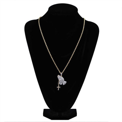 DatNewDrip iced out praying hands pendant on gold rope chain with small cross charm on black bust