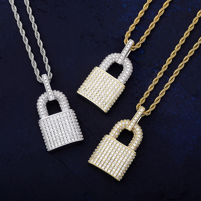 DatNewDrip iced out lock pendant trio in gold and silver with rope chains on dark blue background